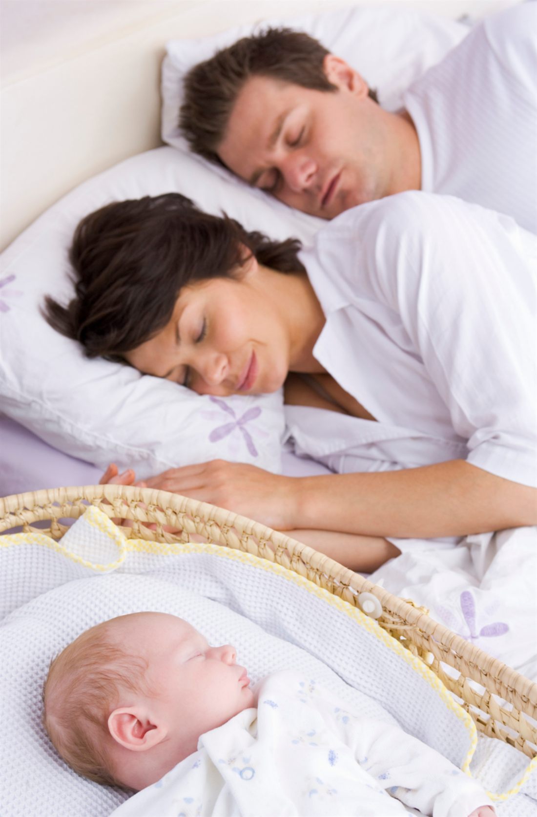 Des parents apaisés près de leur bébé endormi